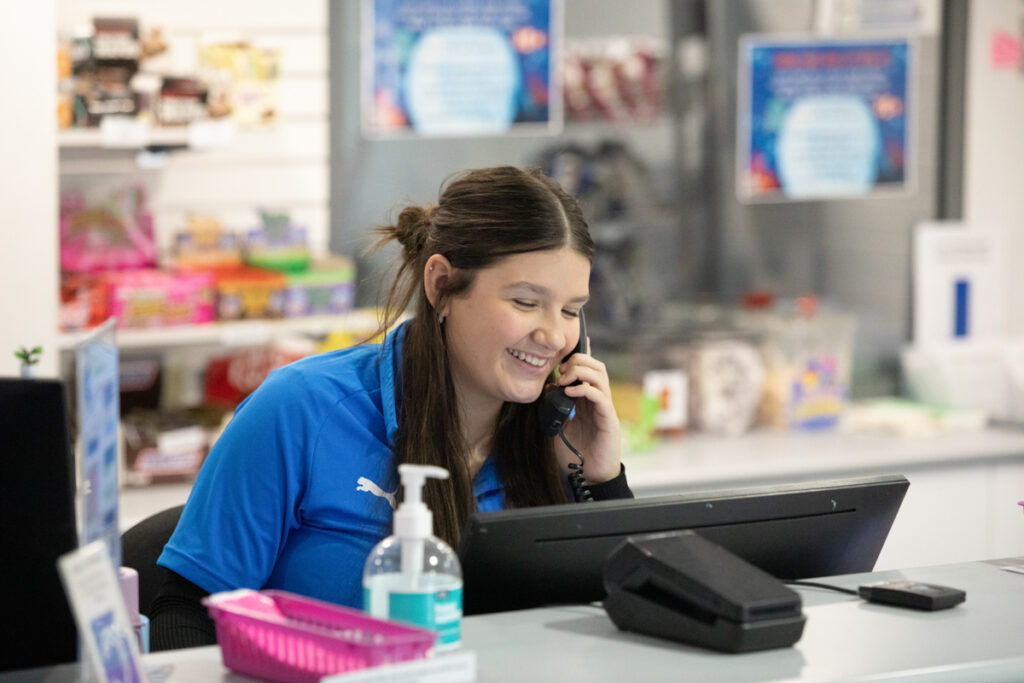 Receptionist smiling whilst taking a call